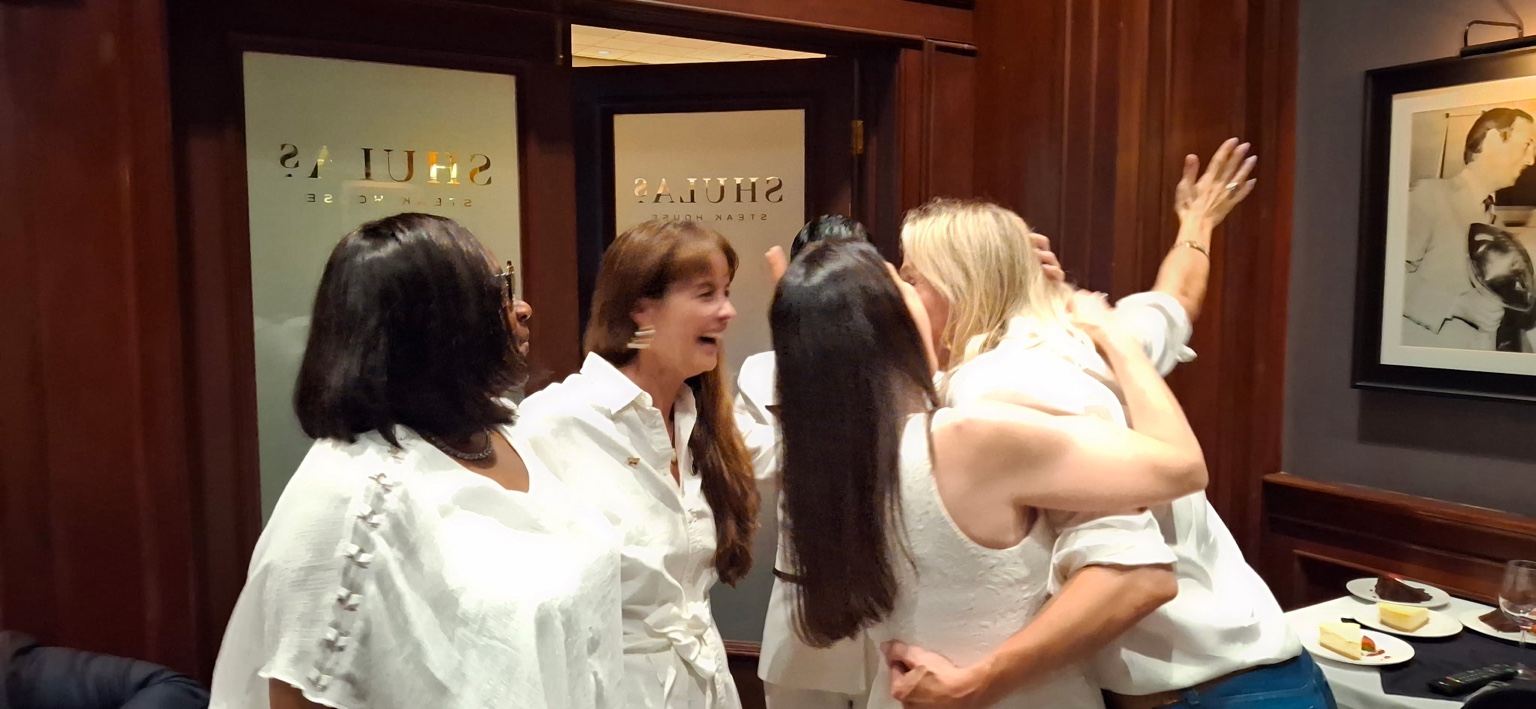 Women from Speakpreneur sharing a joyful embrace